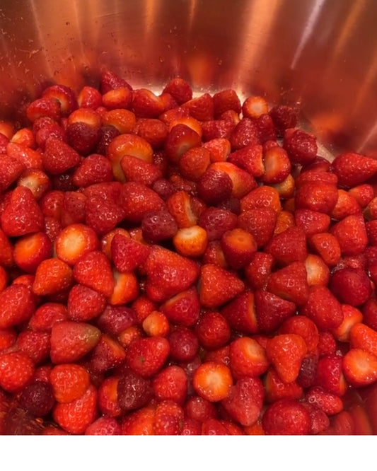 Strawberries prepared for jam making in a copper pan